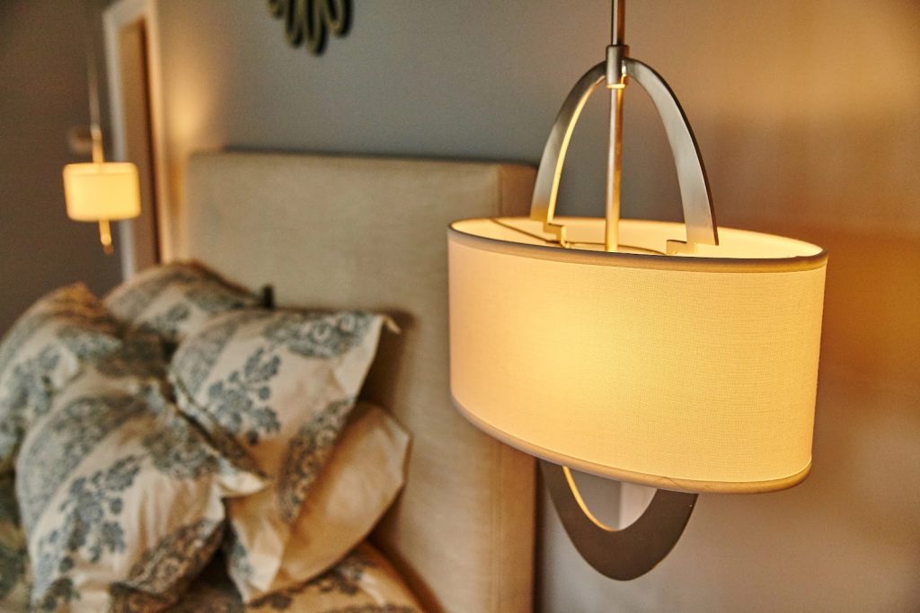 Cómo elegir la iluminación adecuada para cada estancia Lámpara de noche junto a la cama en un dormitorio